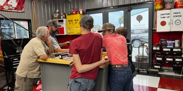 Group of men discussing something in a workshop.
