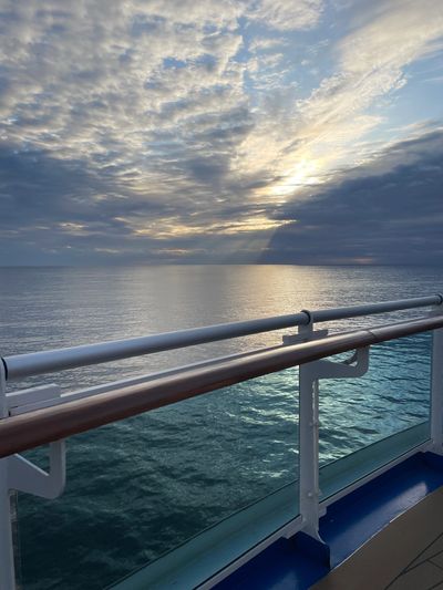 Calm ocean waters with a beautiful, partially cloudy sky from a cruise ship. 
