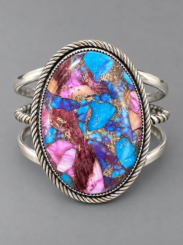 Silver ring with colorful stone and intricate details.