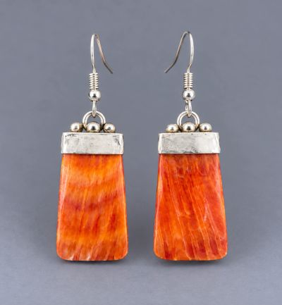 Pair of orange spiny oyster shell dangle earrings with rectangular silver caps and silver-tone ear w