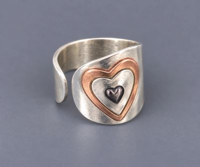 Sterling silver and copper heart ring with a layered heart design and adjustable side-opening band.