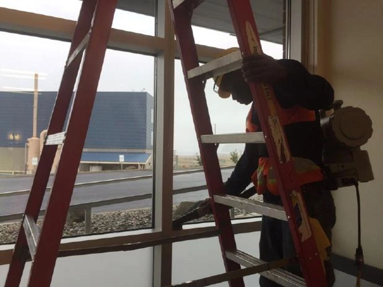 An image of an Accountable employee doing construction cleaning with a shock vacuum on a window sill