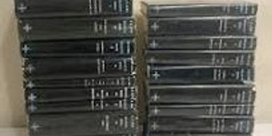 Stack of black DVD or game cases on a white surface.