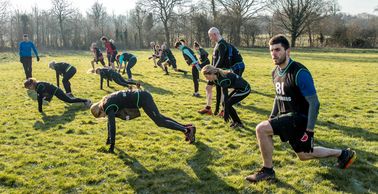 An outdoor fitness class in Cheam with people doing burpees and lunges