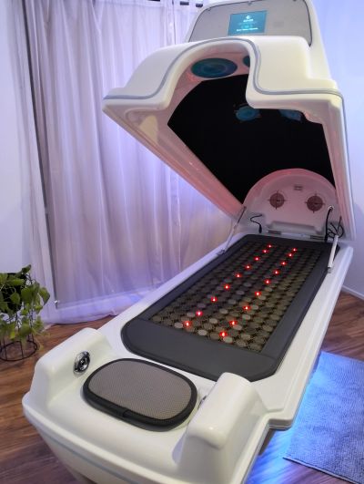 A futuristic wellness or therapy pod with lit red lights.