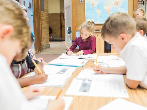 A picture of the kids writing on the paper