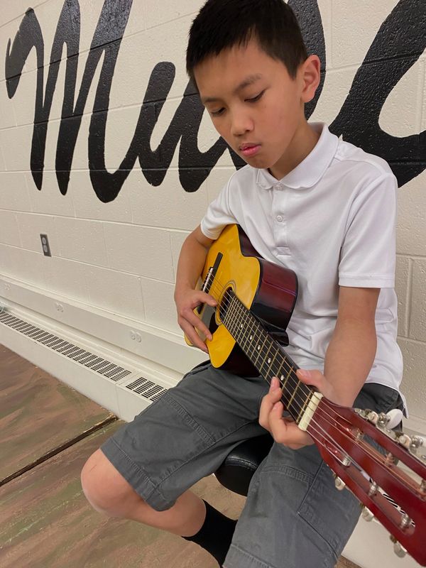 A picture of the boy playing guitar