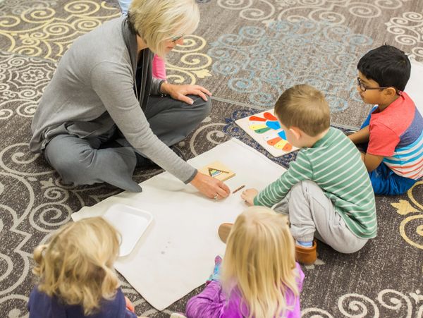 A picture of the teacher teaching kids painting