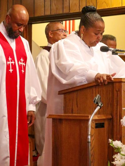 People in white robes during a church ceremony.