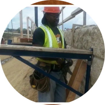 Construction worker wearing safety gear at a worksite.