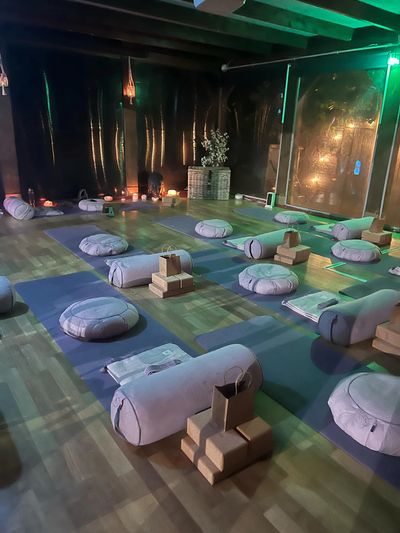 A serene yoga or meditation room with cushions and yoga props arranged neatly.