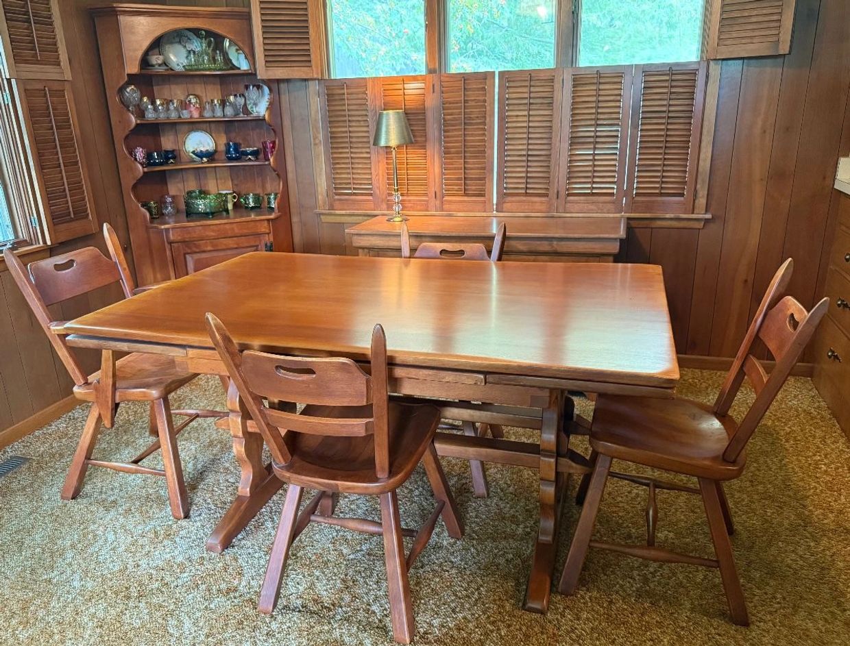 Wooden dining table set in a cozy room with vintage decor.