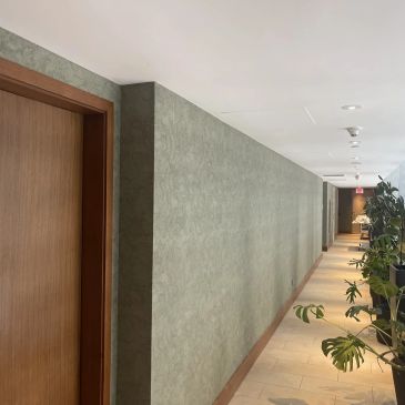 Modern hallway with plants and wooden doors.