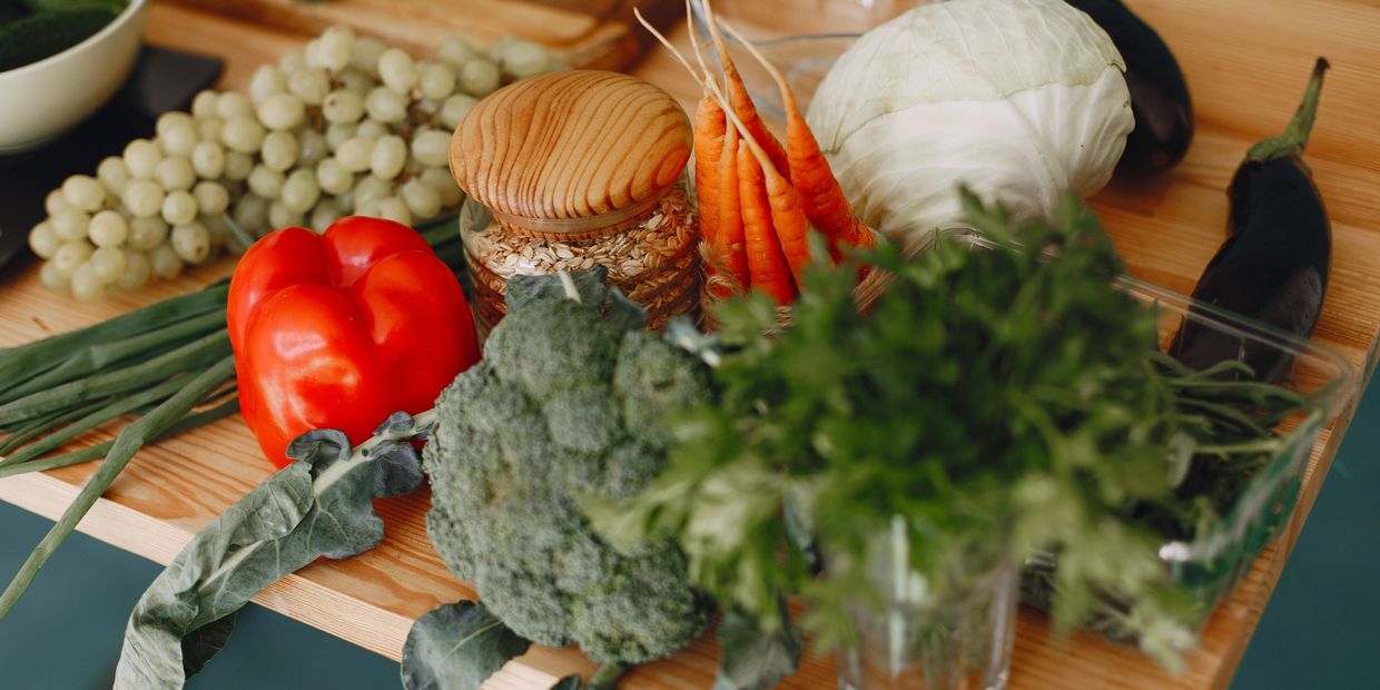 A variety of fresh vegetables and fruits on a wooden table.