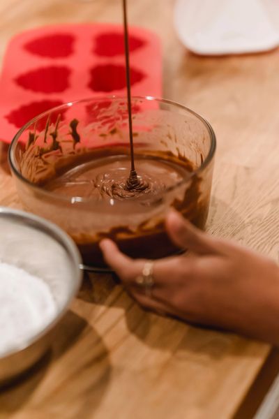 Pouring chocolate batter into a bowl.