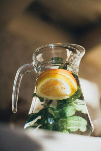 Glass pitcher with lemon and mint-infused water.