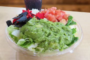 Avocado salad filled with lettuce guacamole onions tomatoes and tortilla chips
