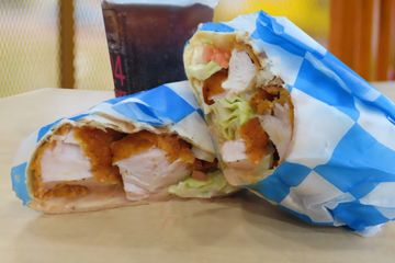 Wrap filled with chicken lettuce tomato blue cheese and buffalo sauce