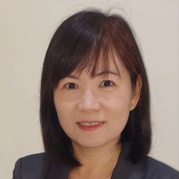 Confident woman in a dark blazer smiling at the camera.