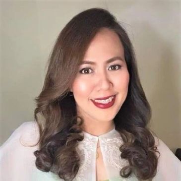 Smiling woman with curled hair and red lipstick.