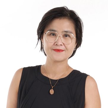 Woman in a black dress and white sneakers posing against a white background.
