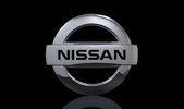 Shiny Nissan logo on a black background reflecting below.