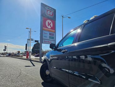 Security vehicle parked near a Phillips 66 gas station sign displaying fuel prices.