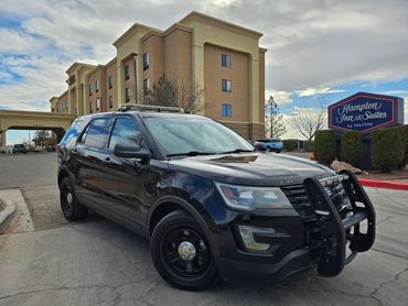 Black police SUV parked outside Hampton Inn & Suites hotel.