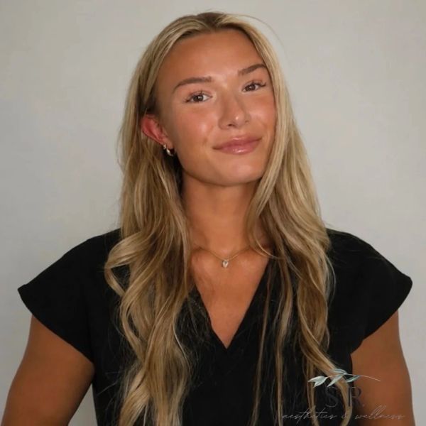 Smiling woman with long blonde hair in black top.