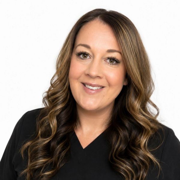 Smiling woman with long curly hair in a black top.