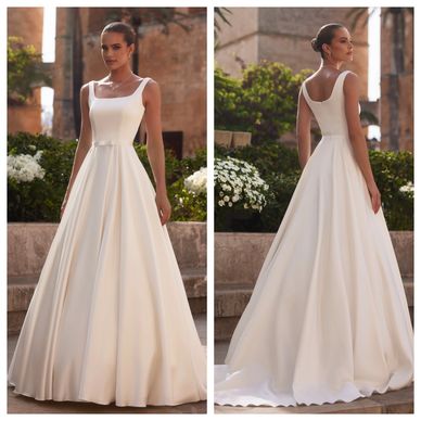 Elegant sleeveless white wedding gown with a flowing skirt and square neckline.