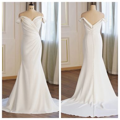 Elegant off-shoulder white wedding gown with buttoned back and flowing train.
