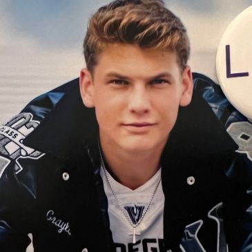 Young man in a letterman jacket.