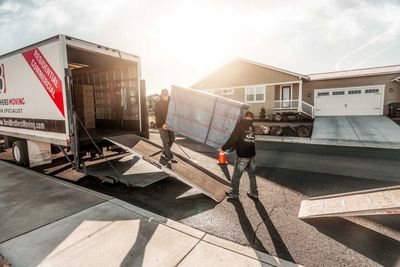 Bend Brothers Moving Truck with 2 Movers loading a large furniture into truck