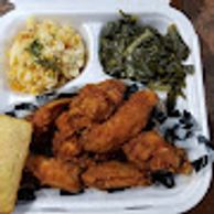 Image of a to go plate with fried chicken, greens, and potato salad. 