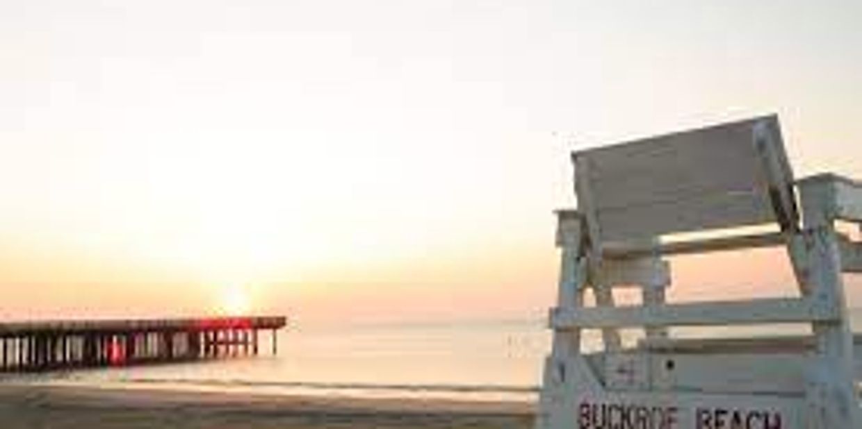 Buckroe beach Pier with the sun rising over it.