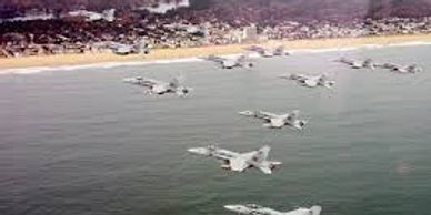 Fighter jet squadron flying in V-formation over the Atlantic ocean. Hampton Movers go the distance