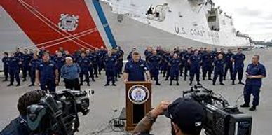 Coast guardsmen are in formation with coast guard cutter.Military Vets are proud of those who serve!