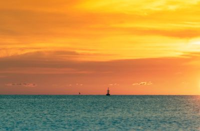 Sunset over the ocean with a buoy in the distance.
