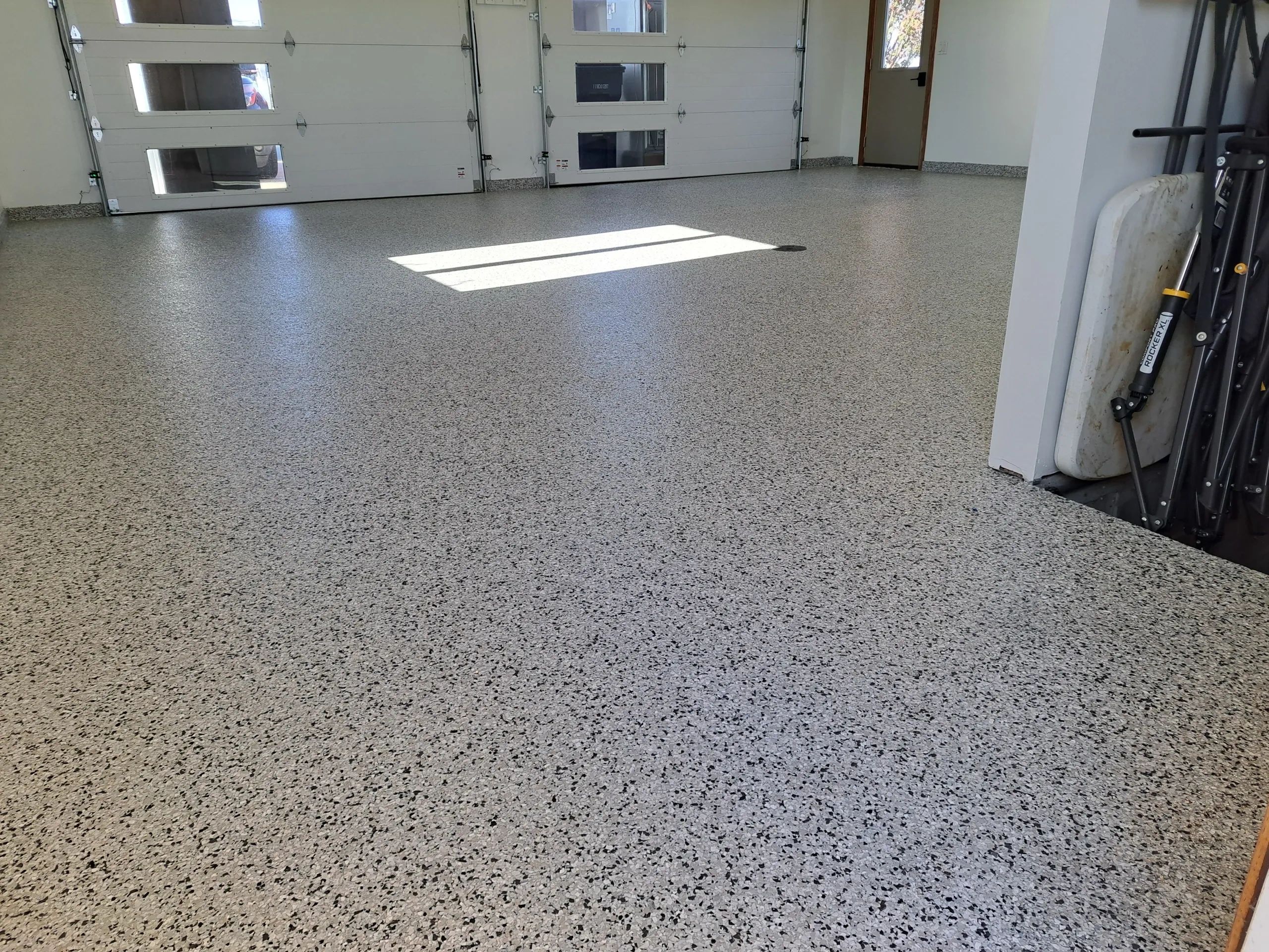 Clean garage with speckled epoxy floor.