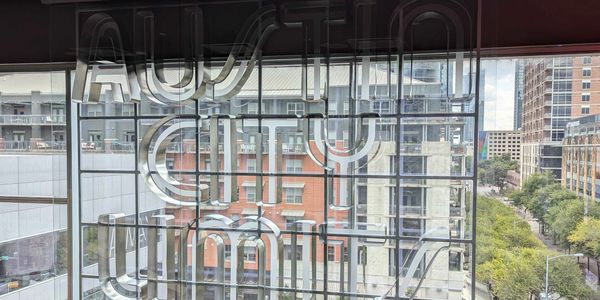 View through tinted glass with reversed text and cityscape outside.