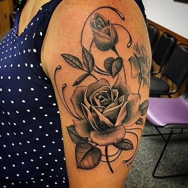 Black and Grey roses on a woman’s arm by Wojo.
