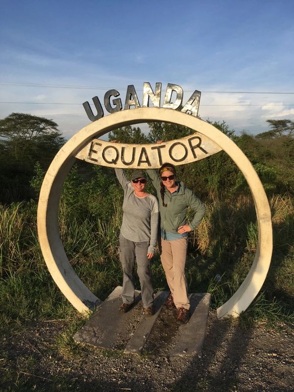 Two women posing at the equator on gorilla trekking safari in Queen Elizabeth National Park, Uganda