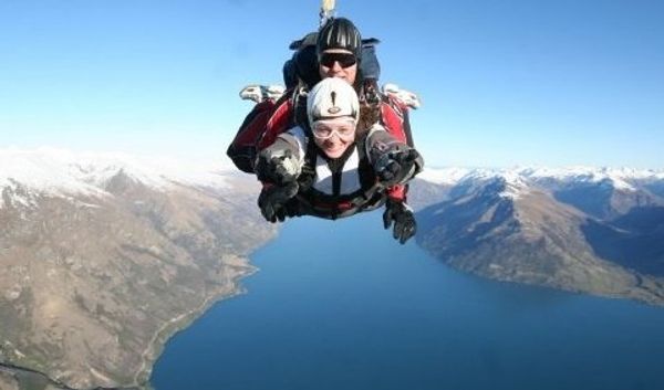 Tandem skydivers in front of the Remarkables mountain range in Queenstown, New Zealand