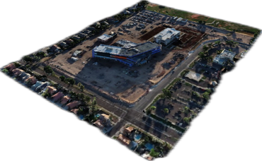 Aerial view of a construction site with large buildings and surrounding residential area.