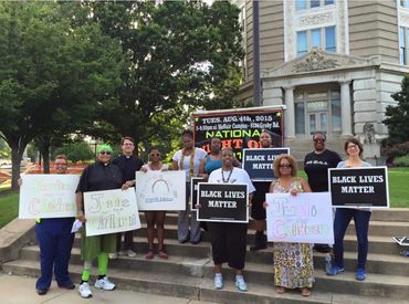 Women standing on steps supporting and holding signs Black Lives Matter.