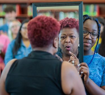 Woman speaking affirmations while looking in the mirror.