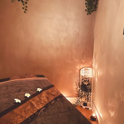 Cozy massage room with soft lighting and floral decor.