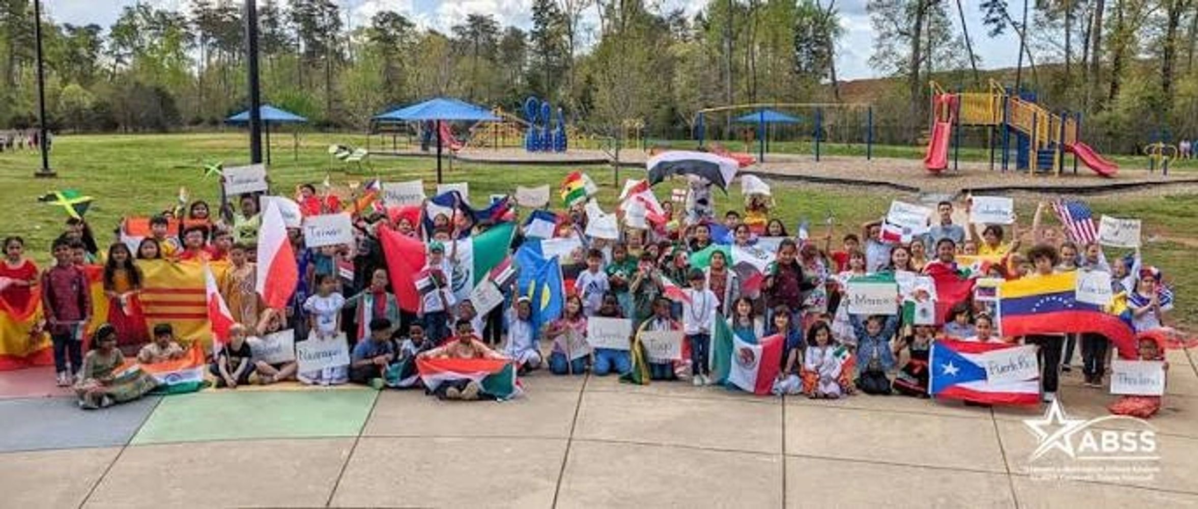 Highland Elementary students holding flags from around the world on the school playground