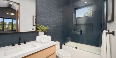 Modern bathroom Remodel with blue tile shower and white countertop in Lake Stevens, Wa